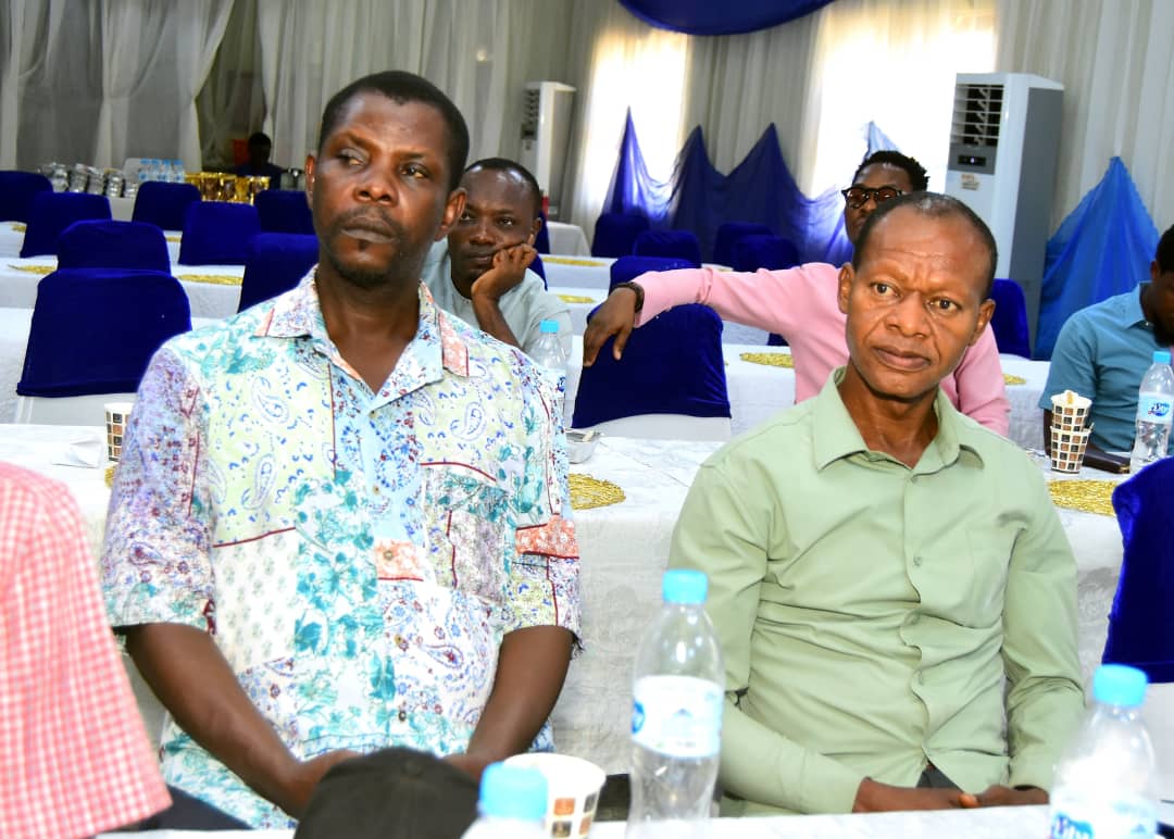 Attendees seated at tables listening