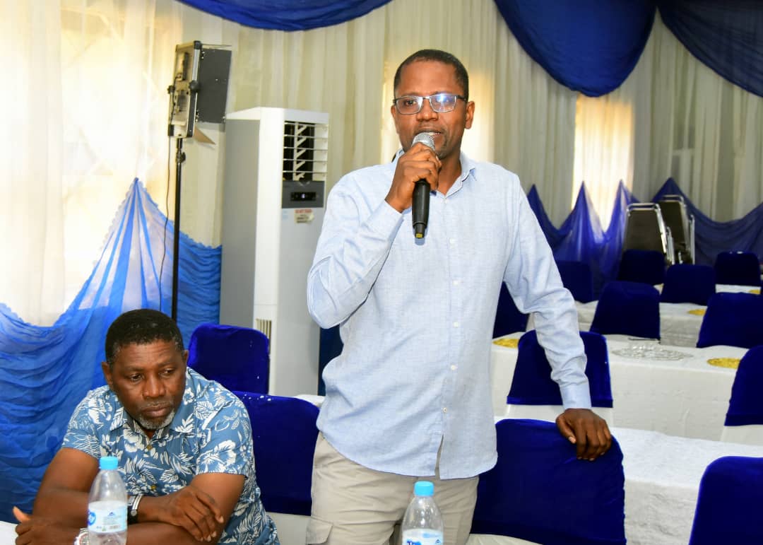 An attendee standing with a microphone to speak from the floor
