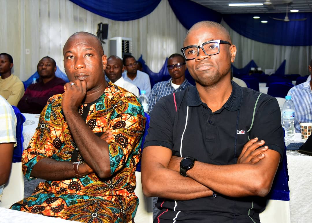 Two attendees seated together, one with arms folded
