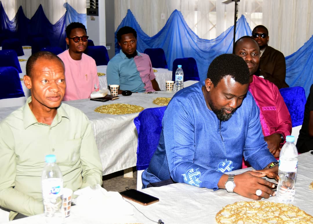 Attendees seated around tables, some looking at their phones
